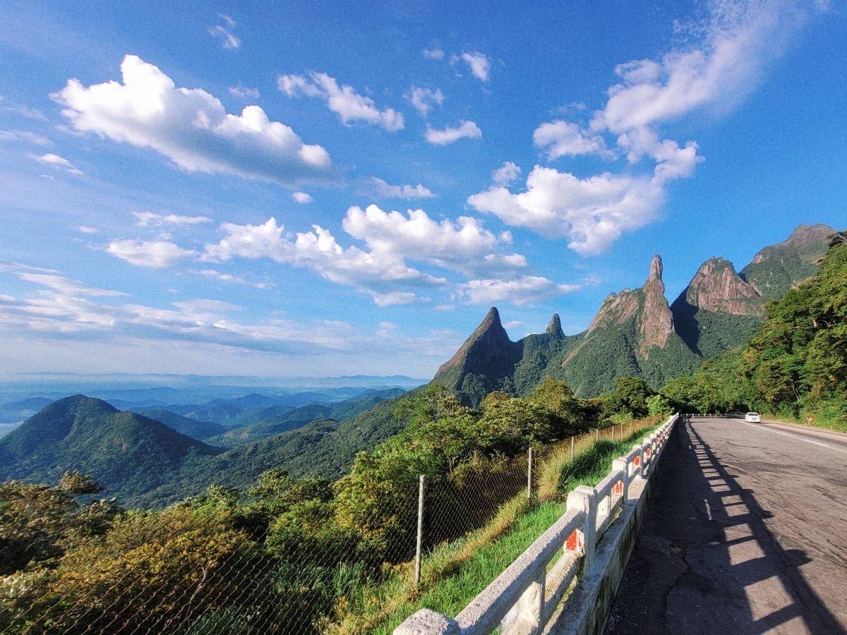 Rodovia de serra num dia de sol, com um carro ao longe